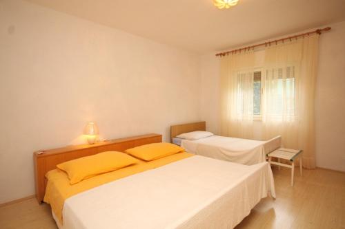 a bedroom with two beds and a window at Apartments with parking space Ugljan - 8479 in Ugljan