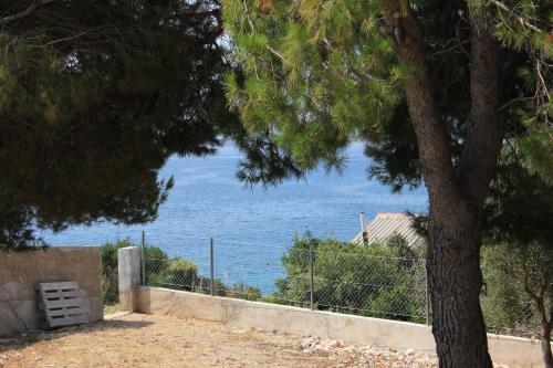 a view of the ocean from behind a tree at Secluded fisherman's cottage Cove Soline, Pasman - 8326 in Kraj