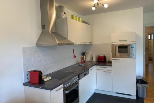 uma cozinha com armários brancos e um forno com placa de fogão em Isabella 4 by SMR Rauris Apartments - inc Spa and National Summercard - near Gondola em Rauris