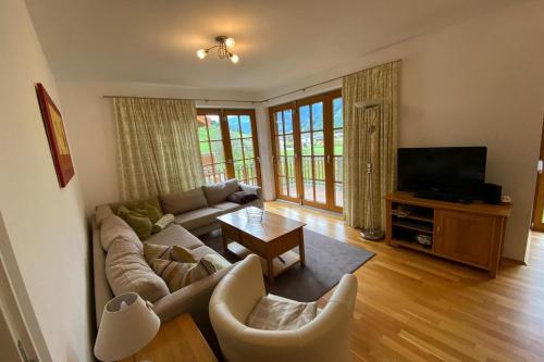uma sala de estar com um sofá e uma televisão em Isabella 4 by SMR Rauris Apartments - inc Spa and National Summercard - near Gondola em Rauris