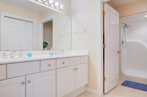 - une salle de bains blanche avec deux lavabos et un miroir dans l'établissement Pink Permuda, à North Topsail Beach