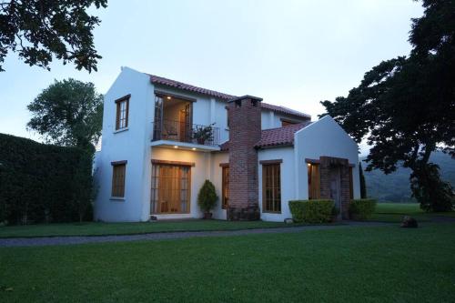 a white house with a balcony on a lawn at 5TO PISO by Bourbon Hostal in Juayúa