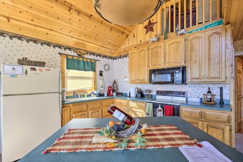 a kitchen with wooden cabinets and a white refrigerator at Hurley Lakefront Hideaway with Fire Pit and Dock! in Hurley