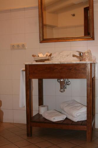 a bathroom with a sink and a mirror and towels at Casa Rural Las Pedrolas in Arnedillo