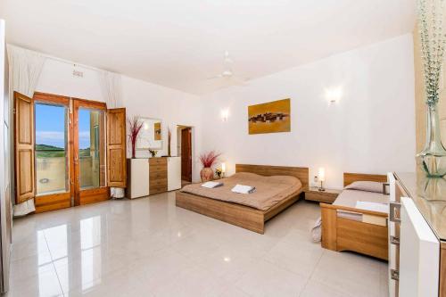 a large room with a bed and a couch at Four Winds Holiday Home in Kerċem