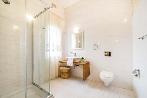 a bathroom with a shower and a toilet and a sink at Four Winds Holiday Home in Kerċem