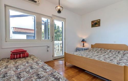 um quarto com 2 camas e uma janela em Apartment Pjescana Uvala 14564b em Pula
