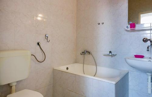 uma casa de banho com uma banheira, um lavatório e um WC. em Apartment Pjescana Uvala 14564b em Pula