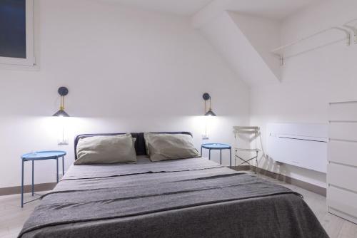 ein Schlafzimmer mit einem großen Bett mit zwei blauen Tischen in der Unterkunft Suite Gharraf Palermo Old Town in Palermo