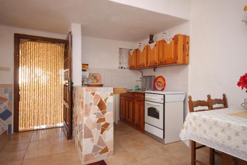 a kitchen with wooden cabinets and a white stove at Apartment Stivan 382c in Štivan