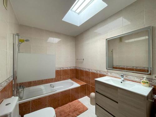 a bathroom with a tub and a toilet and a sink at Modern holiday home in Roquetas de Mar with private terrace in Roquetas de Mar