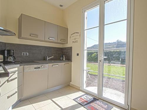 une cuisine avec un évier et une grande fenêtre dans l'établissement Holiday Home near Bayeux and North Sea Beach, à Sainte-Honorine-des-Pertes