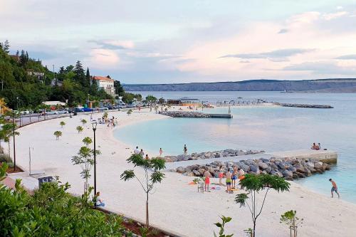 eine Gruppe von Menschen am Strand im Wasser in der Unterkunft Apartments with a parking space Smrika, Kraljevica - 15709 in Šmrika