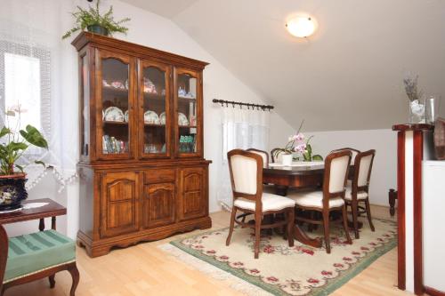 a dining room with a table and a china cabinet at Apartments and rooms with parking space Cunski, Losinj - 2498 in Cunski