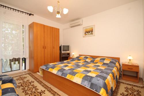 1 dormitorio con 1 cama, TV y ventana en Apartments by the sea Rukavac, Vis - 2411, en Rukavac