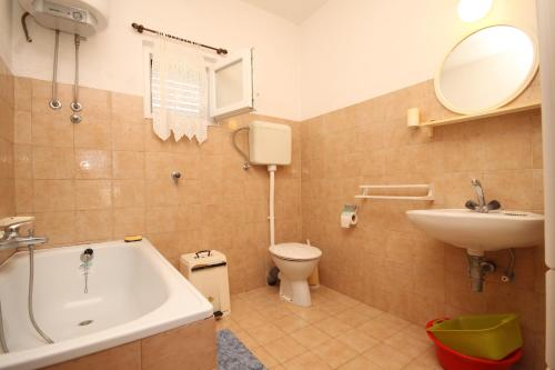 a bathroom with a tub and a sink and a toilet at Apartments by the sea Rukavac, Vis - 2411 in Rukavac
