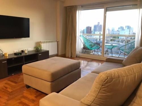 ein Wohnzimmer mit Couch und Flachbildfernseher in der Unterkunft Departamento ROMA 3 Ambientes in Bahía Blanca