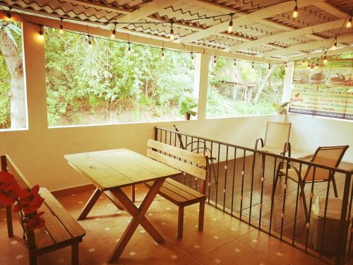 una mesa y sillas en una habitación con balcón en Yuu-Lee Casa Bendita Huatulco en Santa Cruz - Huatulco