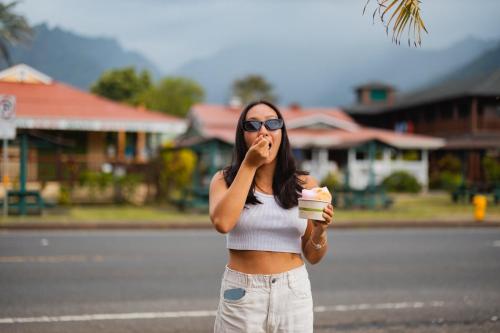 a woman in a crop top eating a cupcake at The Cliffs at Princeville in Princeville