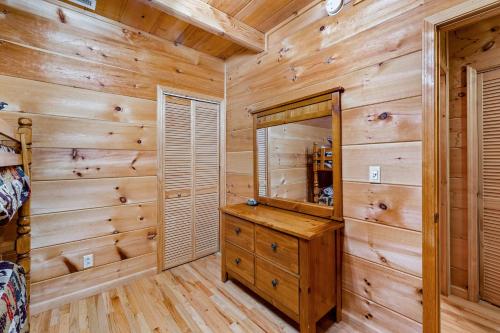 a log cabin bedroom with wooden walls and a large mirror at Rustic Retreat in West Jefferson