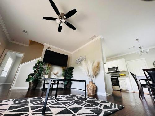 sala de estar con ventilador de techo y mesa en Stylish and Cozy Retreat en Buford