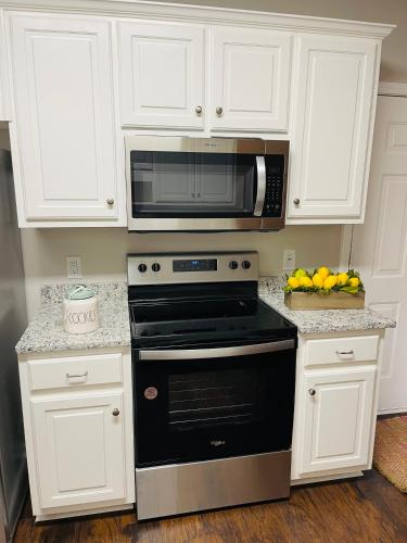 a kitchen with a microwave and a black oven at Stylish and Cozy Retreat in Buford