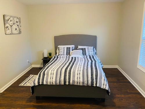 a bedroom with a bed with a striped comforter at Stylish and Cozy Retreat in Buford