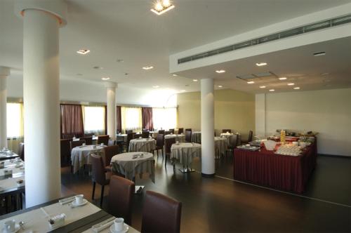 un comedor con mesas y sillas en una habitación en Cosmopolitan Hotel, en Florencia