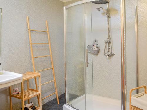a shower with a glass door in a bathroom at The Moorings in Lochmaben
