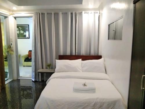 1 dormitorio con 1 cama blanca grande con sábanas blancas en CHIEF'S VILLA Rentals Malapascua Island, en Isla de Malapascua
