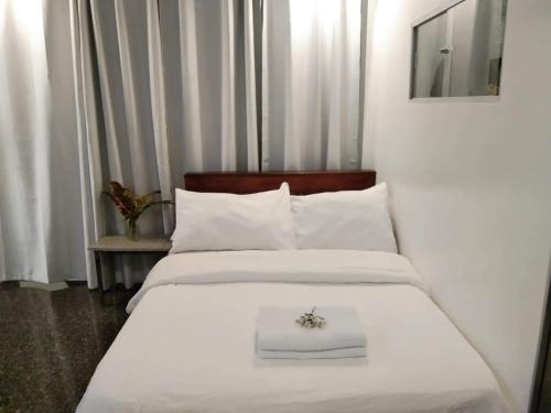 a bedroom with two beds with white sheets and a flower on top at CHIEF'S VILLA Rentals Malapascua Island in Malapascua Island
