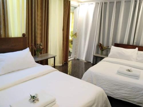 a hotel room with two beds and a window at CHIEF'S VILLA Rentals Malapascua Island in Malapascua Island