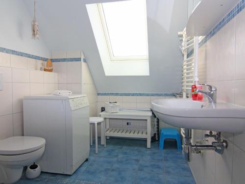 een badkamer met een wastafel, een toilet en een raam bij holiday home Strandloper, Zinnowitz in Zinnowitz