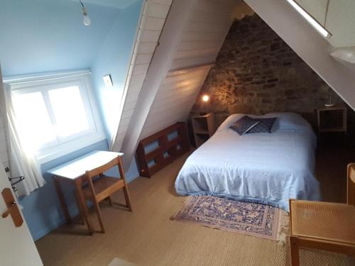 una camera mansardata con letto e finestra di Chez Nany, chaleureux duplex sur le port de Morgat a Crozon