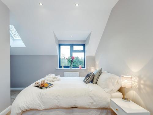 a white bedroom with a large bed and a window at Paddocks View in Breedon on the Hill