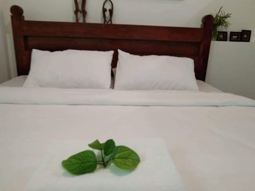 a white bed with a green leaf on it at CHIEF'S VILLA Rentals Malapascua Island in Malapascua Island