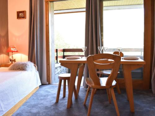 - une salle à manger avec une table, des chaises et un lit dans l'établissement Studio à Méribel avec balcon et casier à ski, proche télésiège - FR-1-180-576, à Les Allues