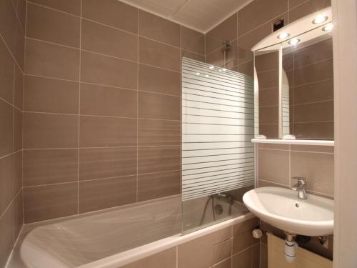 łazienka z wanną, umywalką i lustrem w obiekcie Appartement rénové 3 pièces, 8 pers, proche pistes et commerces - Flaine Forum - FR-1-687-39 w mieście Arâches-la-Frasse
