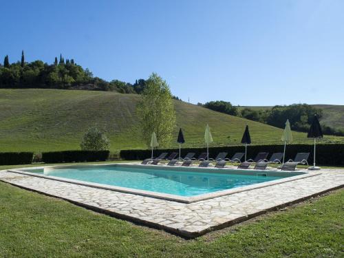 una piscina con sillas y sombrillas en Belvilla by OYO Villa Pomona, en Ghizzano