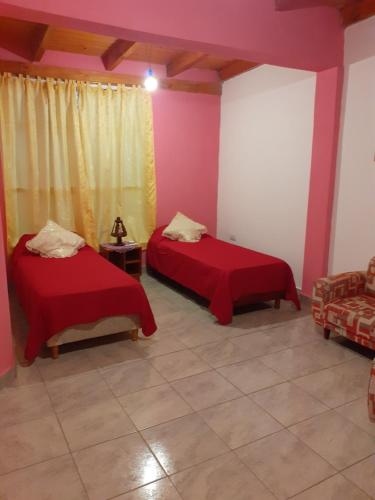a room with two beds in a room with pink walls at La Candela 1 casa in Villa Lonca