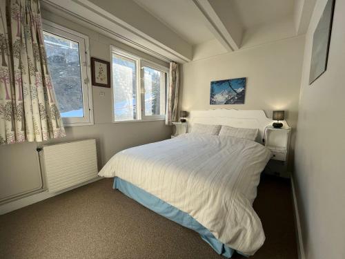 une chambre avec un lit blanc et une fenêtre dans l'établissement 3 pièces pour 8 pers. au pied des pistes, Flaine Forum - FR-1-687-67, à Arâches-la-Frasse