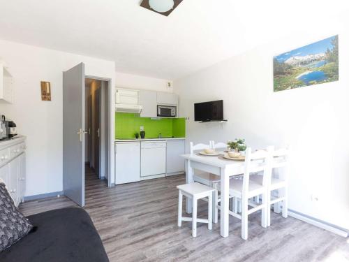 une cuisine et une salle à manger avec une table et des chaises blanches dans l'établissement Appartement confortable près de Saint Lary pour 6 avec parking - FR-1-296-440, à Saint-Lary-Soulan