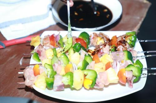 einen Teller mit Lebensmitteln auf einem Holztisch in der Unterkunft Kosgama Riverside Resort in Kosgama