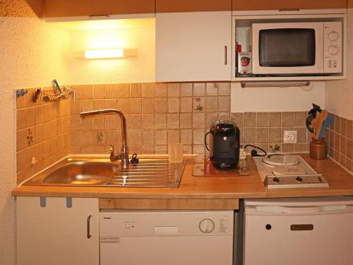 un comptoir de cuisine avec un évier et un micro-ondes dans l'établissement Studio familial avec accès direct aux pistes, balcon sud, 4 pers, centre station, Les Orres - FR-1-322-493, aux Orres