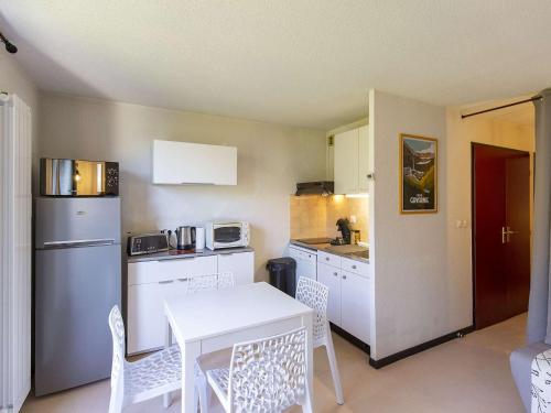 une petite cuisine avec une table et des chaises blanches dans l'établissement Appartement rénové T2, 4 pers., animaux admis, parking, Luz-Saint-Sauveur - FR-1-402-127, à Luz-Saint-Sauveur