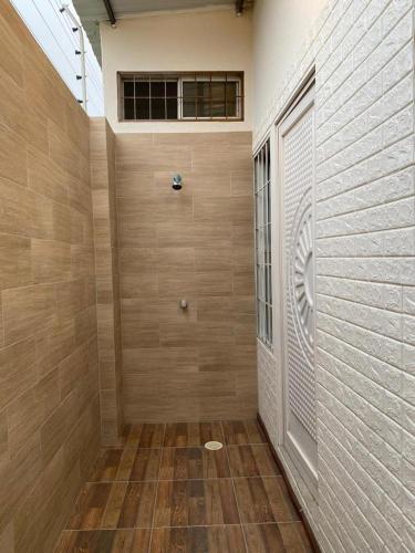 Habitación con ducha, suelo de madera y pared. en Villa en Salinas vía Punta Carnero, en Salinas