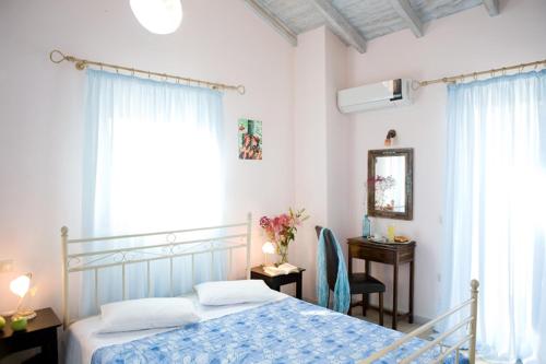 1 dormitorio con cama, escritorio y ventana en Villa Iolis, en Lefkada