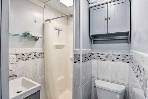 ein weißes Bad mit einem WC und einem Waschbecken in der Unterkunft Cozy Little Piece of Heaven Near Downtown! in Corning