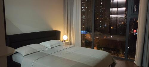 a bedroom with a bed and a window with a city at Full House - The Matrix One in Hanoi
