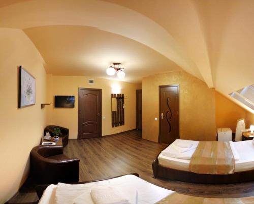 a hotel room with two beds and a couch at Pensiunea Muresul in Târgu-Mureş